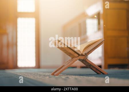 The Holy Quran: The sacred book of Muslims, beautifully displayed in a mosque adorned with Arabic calligraphy. It reflects the deep spiritual signific Stock Photo