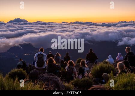 Tourists in awe of the stunning sunrise at Pico do Areeiro as the clouds surround part of the island of Madeira. Stock Photo