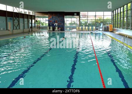 Stadt Neutraubling, Hallenbad. Kleines Nichtschwimmer-Becken sowie ein 25m Becken für Schwimmer. Schwimmbäder dienen der Erholung und der sportlichen Betätigung im, am und unter Wasser. Hauptbestandteil eines Schwimmbades sind Schwimmbecken zum Baden und Schwimmen. Darum gruppieren sich Umkleide- und Duschräume sowie Sitz- und Liegemöglichkeiten. Andere Einrichtungen im Bereich Wellness können das Angebot ergänzen. Für die meisten öffentlichen Schwimmbäder werden Eintrittsgelder erhoben. Als teilweise kostenlose Alternative werden vor allem im Sommer Badeseen genutzt. Private Schwimmbäder sind Stock Photo