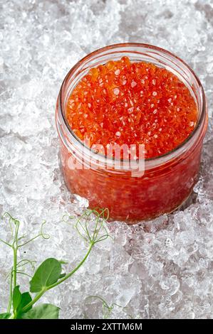 red caviar in a glass jar on ice Stock Photo