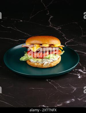 burger with sauce, cheese, vegetables and bacon Stock Photo