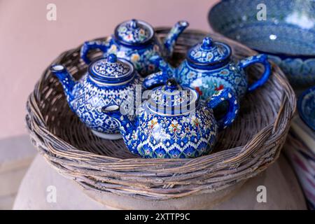 A basket of blue teapots sit on a table Stock Photo