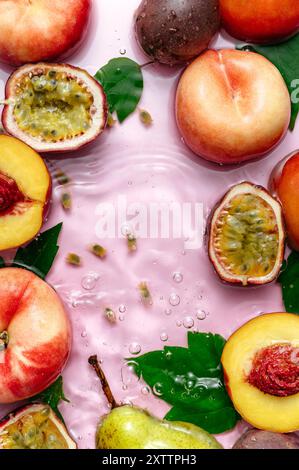 peaches and passion fruit floating in the water. pink background. Stock Photo