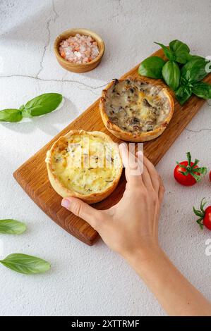 A woman's hand holds a homemade open pie. light background Stock Photo