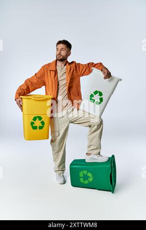 Man displays recycling bins, showing eco-friendly dedication. Stock Photo