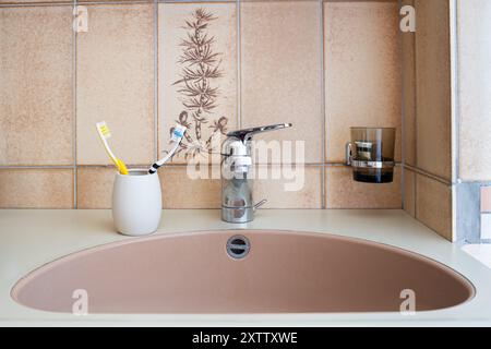 Home bathroom sink and toothbrushes. Close up shot, no people. Stock Photo