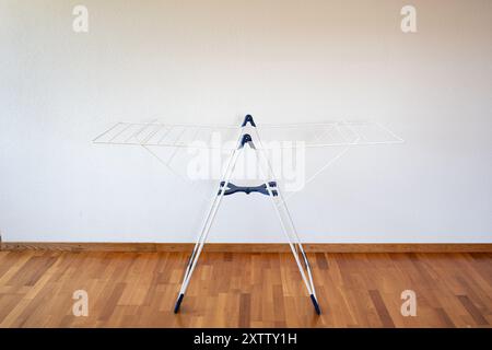 White, empty, plastic clothes hanger inside apartment room, no people. Stock Photo