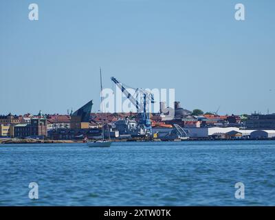 Karlskrona's industrial area from a boat trip, showcasing industrial plants on the horizon and maritime industry within the coastal city's context Stock Photo