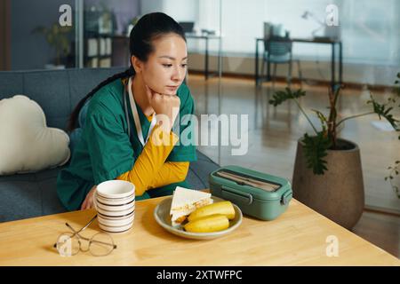 Reflecting While Taking Lunch Break in Cozy Living Room Stock Photo