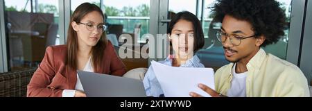 Three coworkers, chat and collaborate on the rooftop terrace during a sunny afternoon. Stock Photo