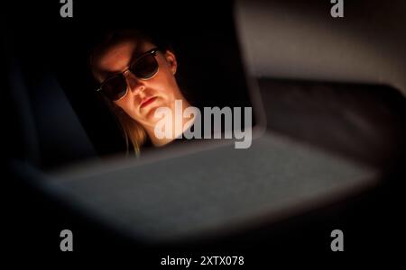 Berlin, Deutschland. 09th Aug, 2024. A face with sunglasses is reflected in a screen in Berlin, August 9, 2024. || Model release available Credit: dpa/17�Թ����� Live News Stock Photo