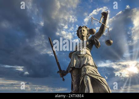 Justitia monument in Frankfurt roemerberg during sunset with cloudy sky, low angle Stock Photo