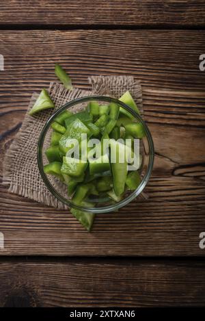 Portion of green Peppers (sliced, selective focus) on wooden background Stock Photo