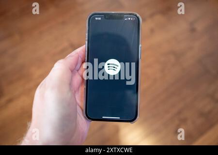 USA. 12th July, 2024. Person's hand holding an iPhone and using the Spotify app, Lafayette, California, July 12, 2024. (Photo by Smith Collection/Gado/Sipa USA) Credit: Sipa USA/Alamy Live News Stock Photo