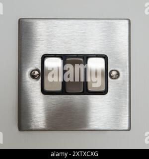 Triple light switch (silver grey metallic brushed aluminum) with screws Stock Photo