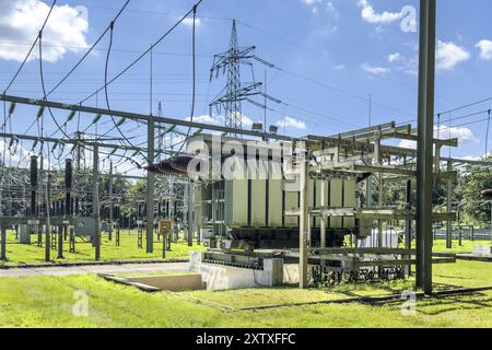 In front large transformer transformer transformer power transformer in transformer station, on the left hanging suspended power lines in the backgrou Stock Photo