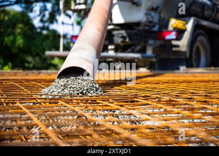 Concrete Being Poured onto Rebar Framework for Ground Slab Construction Stock Photo