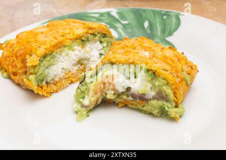 Close-up of two cut pieces, one filled with creamy ricotta cheese and the other with marinated smoked salmon and cream cheese, both wrapped in a baked Stock Photo