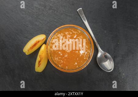 Portion of Peach Jam on a rustic slate slab, selective focus, close-up shot Stock Photo