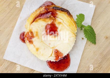 Fresh made Mini Cheesecake (with Sauce) on a vintage background (close-up shot) Stock Photo