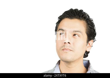 Portrait of a pensive, reserved, handsome hispanic man looking up to the side at blank copy space or product with serious facial expression showing de Stock Photo