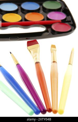 Watercolors palette with transparent colored plastic paintbrushes isolated on white Stock Photo