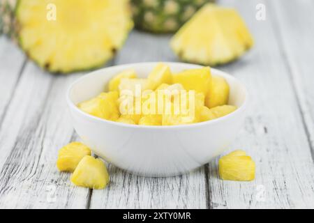 Sliced Pineapple on an old wooden table as detailed close-up shot, selective focus Stock Photo