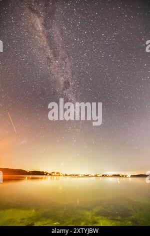 Waterfront of Lake Macquarie reflecting starry night Milky Way galaxy over Southern Hemisphere in Australia. Stock Photo