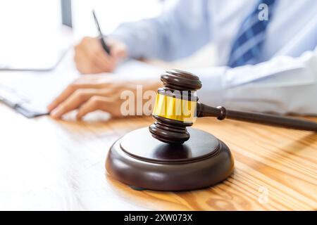 Close up of court gavel with blurred working male lawyer in background Stock Photo