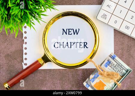 Text sign showing the NEW CHAPTER through a magnifying glass on a piece of paper in a composition with banknotes, a plant and a calculator Stock Photo