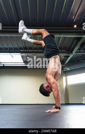 Young latino man with an athletic body doing a handstand Stock Photo