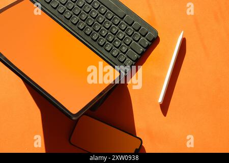 Electronic device blank screen mockup. Orange color. Smart phone and graphic tablet. Stock Photo