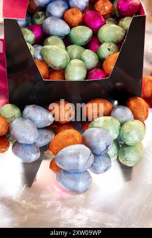 Small Easter Chocolate Eggs in Various Colours coming out of their Boxed Packaging. Stock Photo