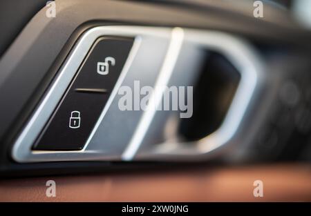 A detailed close-up of an automotive lock button and control panel, showcasing sleek design and advanced technology in vehicle security systems. Stock Photo