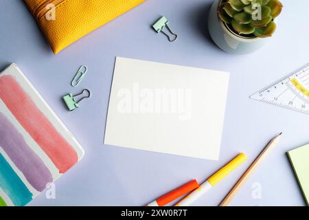 Blank sheet and school supplies, notepad, pencil and felt-tip pens on lilac background. Top view, flat lay, mockup. Stock Photo