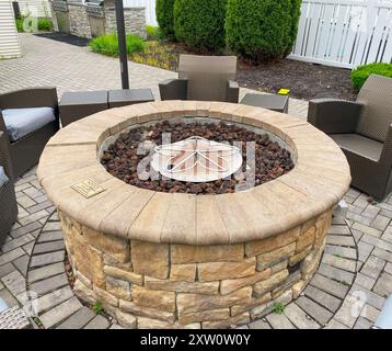 Close up a Hotel Fire Pit surrounded by chairs in a courtyard. Stock Photo