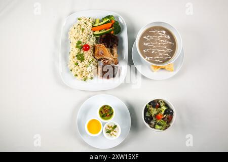 Garlic and Green Pea Fried Rice with grilled vegetable, grill chicken, grill salmon, mushroom soup, Indian raita, salad bowl Stock Photo