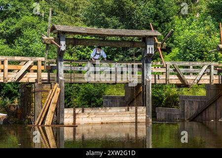 Raftsman Martin Spreng at the weir of the Monhardter Wasserstube. Chain winches can be used to open the raft passage so that rafts up to 286 metres long can be carried downstream on the flood wave. Altensteig, Baden-Württemberg, Germany Stock Photo