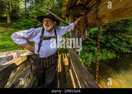 Raftsman Martin Spang from the Upper Nagold Valley Raftsmen's Guild at the Monhardter Wasserstube. It served as a dam to assist the raftsmen in floating timber. Streams were dammed to provide enough water to transport large quantities of timber from the Black Forest to distant areas on rafts. This mechanism was a central component of rafting, which was an important industry in the Black Forest for almost 500 years. Altensteig, Baden-Württemberg, Germany Stock Photo