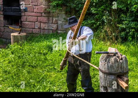 Raftsman Martin Spreng turning wood. The hot pine trunk is clamped into a so-called Wiedstock. There it is turned with a rotating rod, which loosens the wood fibres from each other and creates a kind of wooden rope. Altensteig, Baden-Württemberg, Germany Stock Photo