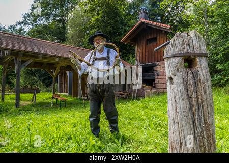 Raftsman Martin Spreng twisting wicker. The twisted material, known as wicker, is woven into rings and later used to bind the rafts. Several hundred wicker strands are often needed for a large raft. Altensteig, Baden-Württemberg, Germany Stock Photo