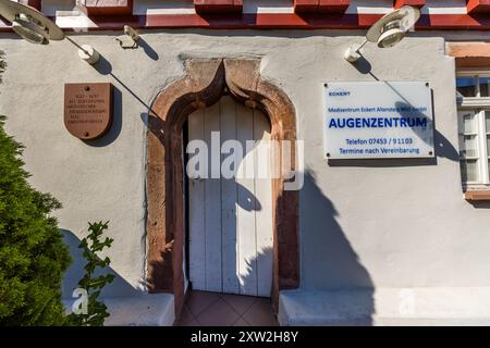 A late-Gothic ogee-arched portal leads into a building on Kaufhausplatz in the old town of Altensteig, Baden-Württemberg, Germany. A plaque dates the house to 1527–1697 as a Bürgerspital (citizens' hospital), with a half-timbered section in Baroque style added in 1612. It now houses the Augenzentrum eye clinic of the Medizentrum Eckert practice. Stock Photo