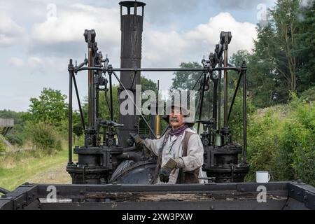 Train Driver at the controls of the Reproduction Puffing Billy engine at the Beamish Museum, County Durham, UK Stock Photo