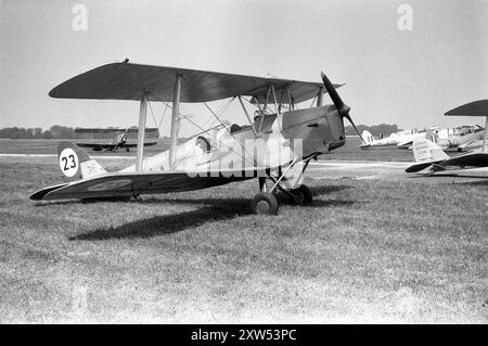 England. circa.1957 – A de Havilland DH.82A Tiger Moth of ‘The Tiger Club’, registration G-AOAA. In the background are two other Tiger Moths, one belonging to The London Gliding Club, and two de Havilland DHC-1 Chipmunks, one with the registration WB549. The latter was the first Chipmunk built in the United Kingdom. (G-BAPB). Stock Photo