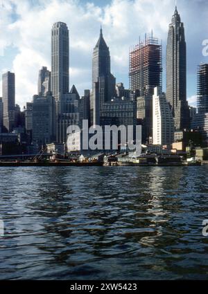 New York, USA. September 1959 – A view of the Lower Manhattan skyline taken from the East River, New York. Pier 11 and 99 Wall Street Building are visible in the foreground. The buildings behind include the City Bank–Farmers Trust Building,  the Bank of Manhattan Trust Building and the Cities Service Building. The photograph also shows the One Chase Manhattan Plaza building under construction. Stock Photo