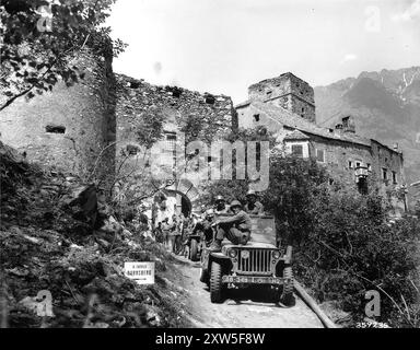 A jeep from the U.S. 5th Army leaving Dornsberg castle after having found large quantities of silk, wool and other goods looted by the Nazis. The civilian (no helmet) in the first jeep is Doctor van Hartner, from the International Red Cross from Budapest who guided the Americans to places where looted items were hidden. Stock Photo