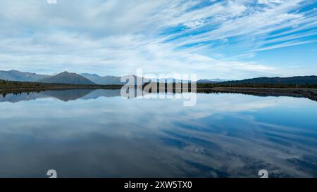 Remote Kapitea Reservoir reflections surrounded by mountain ranges ...