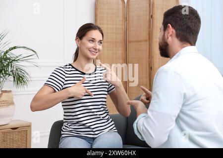 Man and woman using sign language for communication at home Stock Photo