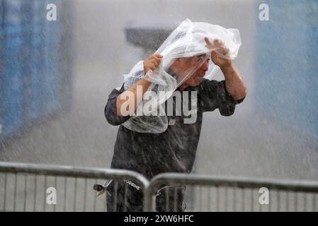 A security person is protecting himself from the rain at Woodbine Racetrack in Toronto, Canada, on August 17, 2024. Canada's premiere thoroughbred horse race, The King's Plate, is being cancelled for horse safety due to excessive rainfall on track surfaces. (Photo by Mike Campbell/NurPhoto)0 Credit: NurPhoto SRL/Ģ����ý Live News Stock Photo