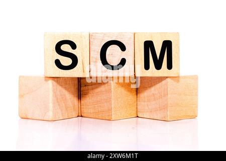 SCM short for Supply Chain Management. SCM on wooden cubes on a white background. Stock Photo